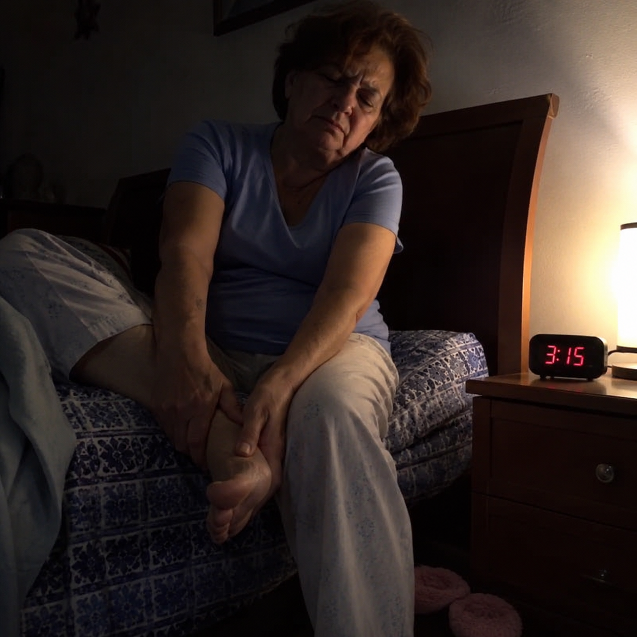 Senior woman awake at night from neuropathy foot pain